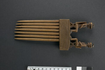 Material number: UEM27071&amp;#160;
Material: Wood&amp;#160;
Region and culture: Could belong to the Chokwe people
Description:&amp;#160;Wooden comb where two male figures wearing hats are sitting on chairs facing each other. Stylistically the object resembles combs deriving from the Chokwe people. Decorated objects, like this comb, were used as power symbols amongst the Chokwe chiefs.&amp;#160;&amp;#160;
The object was delivered to the Ethnographic museum as part of&amp;#160; Dr. Inge Heibergs collection.&amp;#160;1903-1920.
