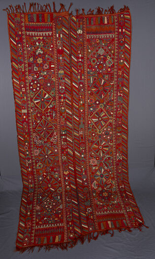 (UEM49197) The&amp;#160;background color is lighter here than on the other blankets. Double borders, all four vertical edges of the panels have the characteristic multi-colored diagonal pattern. The center of each panel has four diamonds and each of the ends of the panels terminates with a pointed arch. The whole is interspersed with flowers and living creatures (birds, camels, fish, and other animals).&amp;#160;