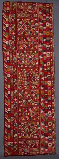 (UEM49198) Triple borders at each vertical edge of the two panels. Outer edge of each panel has the characteristic multi coloured diagonal lines pattern. The other borders have geometrical /vegetal motifs. In the centre length wise are four big diamonds surrounded by a pattern of uniform flowers. All four ends of the panels are closed in with a triangle in which a human fig. Other motifs elsewhere: birds, flowers and trees.&amp;#160;