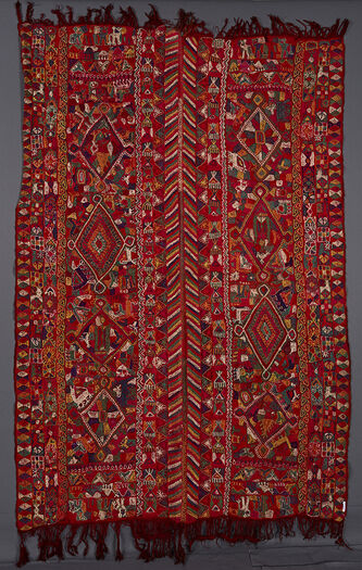 (UEM49201) Triple borders along the vertical edges. The two innermost borders have the characteristic multi coloured diagonal lines pattern. Vertically on both panels there are 4 diamonds containing and surrounded by human figs. riding or bearing things on head and imaginary animals ressembling snails, birds, tortoises,cats, bovines (four legged) camels etc. Central motif on each of the pannels: four diamonds.&amp;#160;
&amp;#160;
Crochet embroidered wool twill cloth. Different from the others in the series in that this one is decorated on a green background. The two vertical borders/edges, unlike the others, does not have the diagonal lines pattern.&amp;#160;Each vertical panel has four big diamonds surrounded by flowers. two male figures in each panel. Fringes not knotted. To be revised and completed, object not available.&amp;#160;