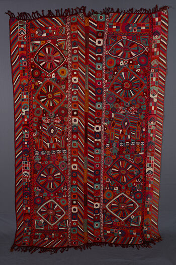 (UEM49204) Both panels have double vertical borders with the characteristic multi cloured diagonal lines pattern on all four edges. The motifs are all bold. In the centre of both panels there is a small diamond with two bigger diamonds on either side. In the middle of these is a big flower with ray like petals.Other motifs consist of pecking birds, human figures (girls with blue or red hair in a row, and dancing girls), flowers and geometrical patterns.&amp;#160;&amp;#160;