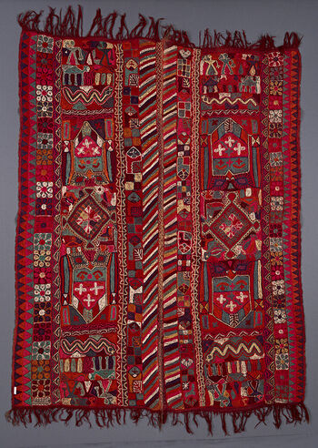 (UEM49209) This blanket has&amp;#160;double borders, where only the inner edges of the two panels have the characteristic multi coloured diagonal lines pattern. The outer edges have a border of small two- colourd diamonds. Vertically in each panel: in the centre a diamond surrounded by animals on either side,then a shield-like/house-like motif, then on either side (a symetrical design) a snake and at each of the ends a section with human figures and long legged animals.&amp;#160;
