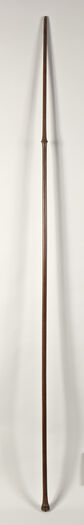 Museum number: UEM185
Material: Wood
Region and culture: Possible Cook Island, French Polynesia or New Zealand
Description:&amp;#160;Wooden lance or staff. Though its documentation states it derives from New Zealand, most likely it originated in the Austral Islands, due to its conical knot being identical to the wooden paddle (UEM160). The staff is approximate 2,3 m long. The knot consist of eight carved human heads, followed by a field of carved zig-zagging shark tooth patterns, along with a linear pattern field as well. The entire staff is very finely polished. The object had most likely a ceremonial function. Its production date is not known, but it was probably acquired around 1856.&amp;#160;The lanse would have been carved with either metal tools introduced after European contact or with their own indigenous carving tools such as shark teeth or shell. Most objects from the Austral Islands are composed of three design elements: concentric circles, minute rows of nested crescents, and x-shaped motifs. However, the motifs found on different objects are used in such a vast array of combinations, that no two objects would appear the same.&amp;#160;&amp;#160;